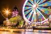 Long exposure photo of a ferris wheel next to a historical landmark in Leeds, England