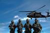 Four Soldiers Carrying Rifles Near Helicopter Under Blue Sky