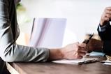Photo of arm across a desk to signify a meeting, giving advice