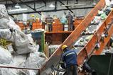 Workers on a conveyor belt in a recycling plant