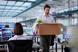 employee walks through office with cardboard box