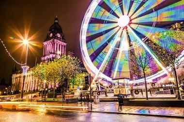 Long exposure photo of a ferris wheel next to a historical landmark in Leeds, England