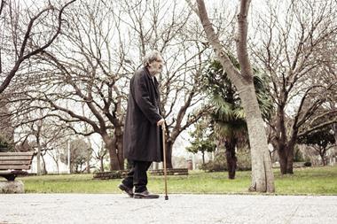 old man walking with stick in park