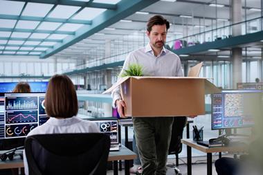 employee walks through office with cardboard box