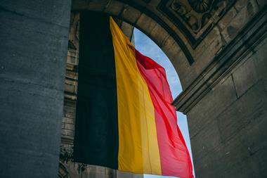 Belgian flag hanging down from a historical arch
