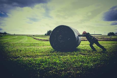 pushing back hay bale field