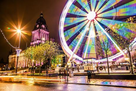 Long exposure photo of a ferris wheel next to a historical landmark in Leeds, England