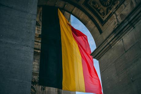Belgian flag hanging down from a historical arch